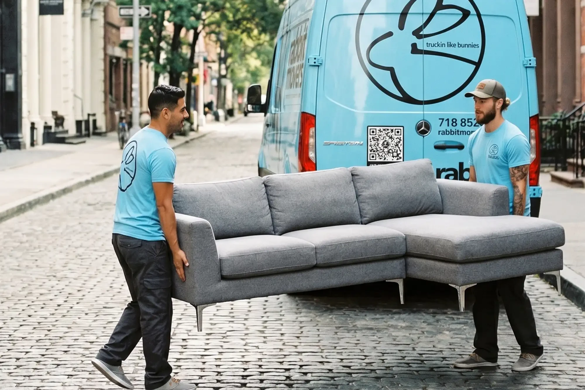 Rabbit Movers branded van and crew on a NYC cobblestone street